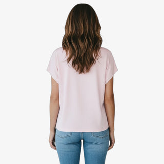 Person wearing a light pink t-shirt and blue jeans on a white background