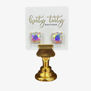 Iridescent cushion cut stud earrings set in gold on white card with gold stan