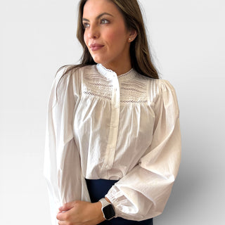 White pintuck cotton blouse with delicate pleated front detail and feminine silhouette shown on model, classic white blouse perfect for workwear, brunch outfits, and polished everyday style