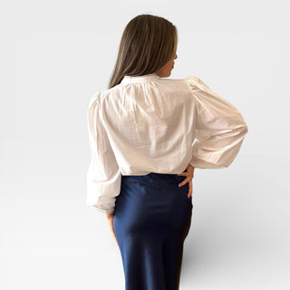 Back view of the white pintuck cotton blouse shown on model, classic white pintuck blouse perfect for workwear, brunch outfits, and everyday style