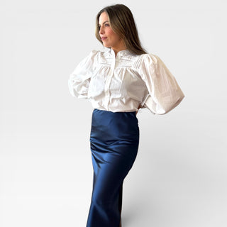 Navy satin slip skirt with sleek midi silhouette and smooth drape shown on model, elegant navy skirt perfect for workwear, evening outfits, and polished everyday style