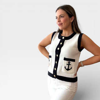 Woman wearing a sleeveless top with anchor design on a plain background
