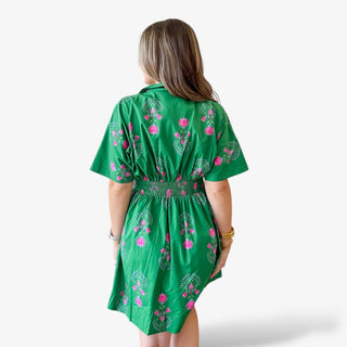 Green floral mini dress back view with pink floral print, smocked elastic waist, short sleeves, and flowy skirt for a flattering spring and Easter outfit.