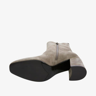 Taupe ankle boot with a black sole on a white background