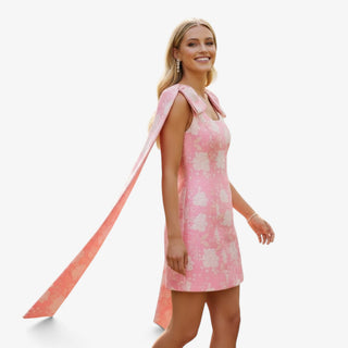 Pink jacquard bow mini dress with floral pattern and dramatic shoulder bow detail side view