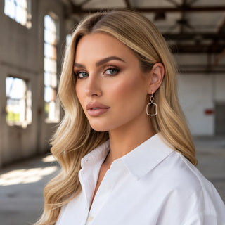Kitzi two tone square drop earrings on model featuring silver geometric drops with gold accents