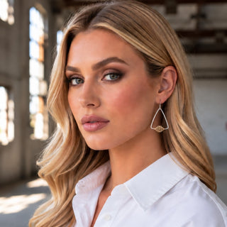 Kitzi Triangle Drop Earrings on model showing silver open triangle design with gold center accent