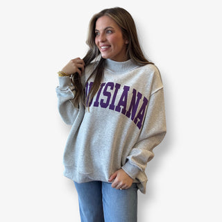 Woman wearing a gray sweatshirt with 'Louisiana' printed on it against a white background