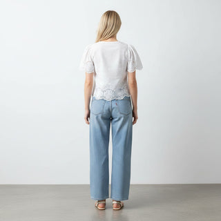 white eyelet crop top puff sleeve blouse styled with jeans back view
