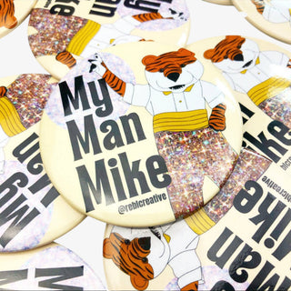 3-inch My Man Mike game day button featuring a tiger mascot in sparkling gold pants on a cream background, front view