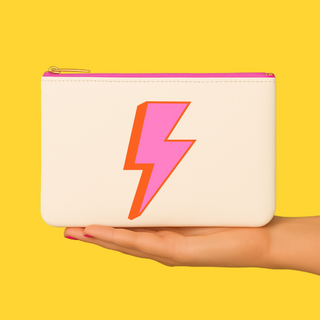 Lightning bolt cosmetic bag displayed in hand with yellow background lifestyle image
