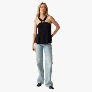 Woman wearing the black Michael Stars Imani Top with ring halter neckline and light wash jeans