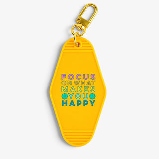 Yellow motel keychain with colorful Focus On What Makes You Happy lettering and gold-tone clasp, front product view.