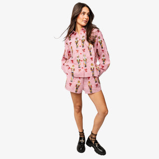 Model wearing Queen of Sparkles Nutcracker & Bow Button Up Top with red and white stripes and sequin nutcracker details