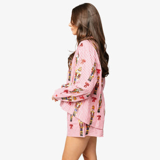 Model wearing Queen of Sparkles Nutcracker & Bow Button Up Top with red and white stripes and sequin nutcracker details