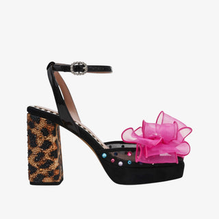 Black high-heeled shoe with leopard print platform and pink bow on a white background