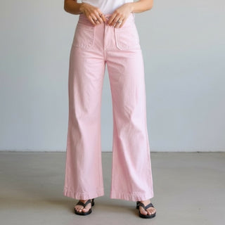 Women’s pink patch pocket wide leg pants styled with a white top and black sandals, front close-up view.