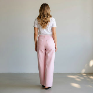 Person wearing a white t-shirt and pink denim pants with wide legs and a high rise.