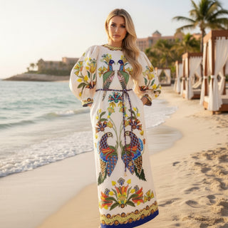Women’s peacock print maxi dress with puff sleeves and flowy silhouette on tropical beach
