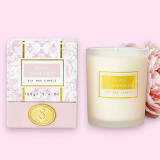 8 Oak Lane Boxed Candle with Peony Grapefruit Soy Wax Candle 5.6 oz on a clear candle with gold 