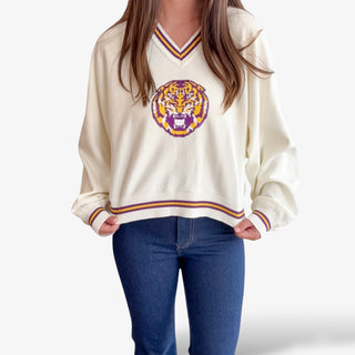 Woman wearing Queen of Sparkles Striped Cuff Sweater with sequin mascot and jeans. 