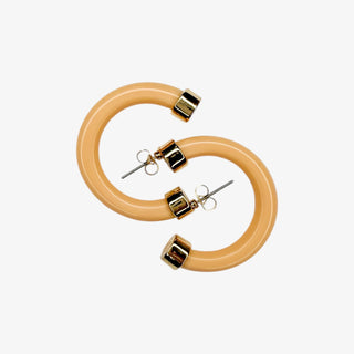 Pair of beige hoop earrings with gold accents on a white background