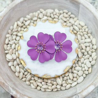 Purple flower-shaped statement earrings with gold accents and a central lavender gemstone