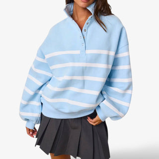 Light blue sweater with white stripes worn by a person on a white background