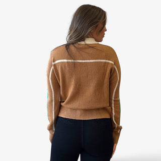 Woman wearing a brown sweater with white stripes on a white background