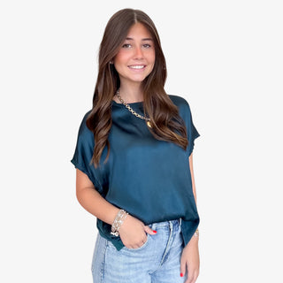 Woman wearing Michael Stars Flow rainforest top and denim jeans on a white background