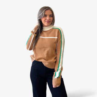 Woman wearing a brown sweater with white and green stripes on a white background