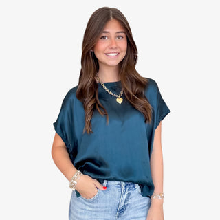 Woman wearing the Michael Stars Flow top in Rainforest satin with denim jeans on a white background