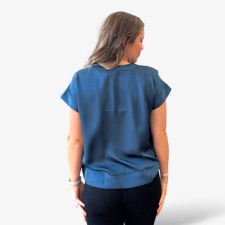 Woman wearing a blue top from behind on a white background
