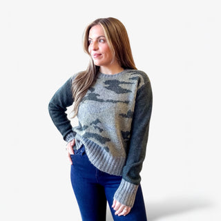 Woman wearing a camouflage sweater against a white background