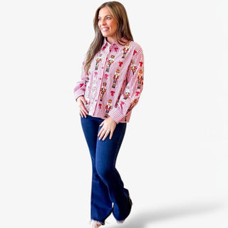Woman wearing a colorful patterned shirt and blue jeans on a white background