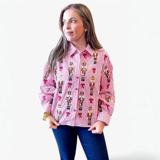 Woman wearing a red and white striped shirt with decorative patterns on a plain background