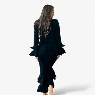 Woman wearing a black set with ruffled sleeves and bottom on a white background