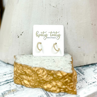 Classic gold hoop earrings with polished finish displayed on jewelry card