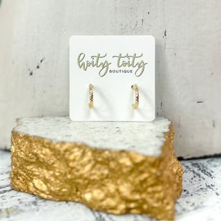 Classic gold hoop earrings with polished finish displayed on jewelry card