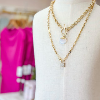 Opal gemstone gold filled pendant necklace with toggle clasp layered with chain necklaces on mannequin