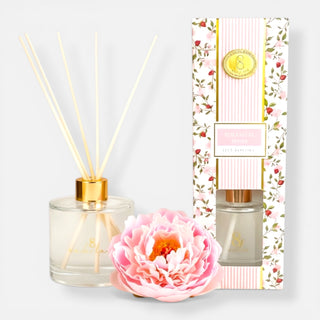 Botanical Berry reed diffuser set with floral design packaging and a pink flower on a light gray background
