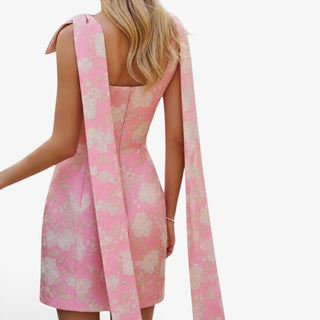 Pink jacquard bow mini dress with open back detail and oversized bow tailbaccents back view