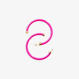 Bright pink acrylic hoop earrings with gold-tone accents on white background


