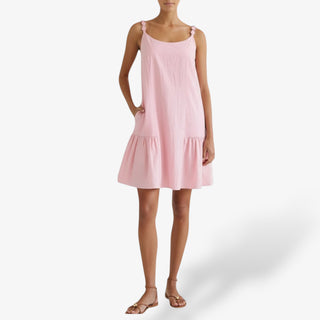 Pink ruffle mini dress with button straps styled with flat sandals full outfit view