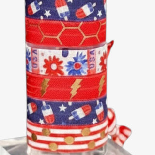 Red white and blue patriotic hair tie set featuring popsicle prints, gold lightning bolts, floral patterns, and striped polka dot ribbon details