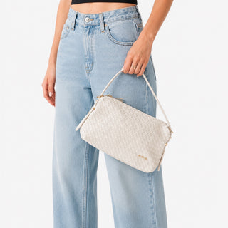 Pretty Simple Harper cream woven crossbody bag carried by model, side angle lifestyle view