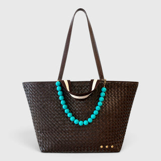 Pretty Simple Mindi Bag Charm/Necklace in aqua with glossy beaded design styled on a brown woven tote, convertible necklace or bag charm front view.