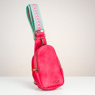 Fuchsia sling bag with pink and turquoise adjustable strap isolated product view