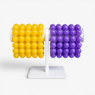 Purple and gold chunky bead bracelet with glossy round beads for game day styling, on a white bracelet bar on a white background.