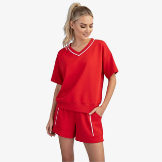 red scuba v neck top with white piping relaxed fit styled with matching shorts front view